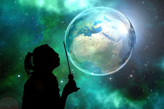 silhouette of someone holding a wand in front of Planet Earth