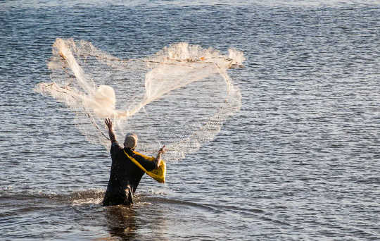 Traditional skills: a man fishing in the harbour of Apia, Upolu, Samoa.  (traditional skills help people on the tourism deprived pacific islands survive the pandemic)