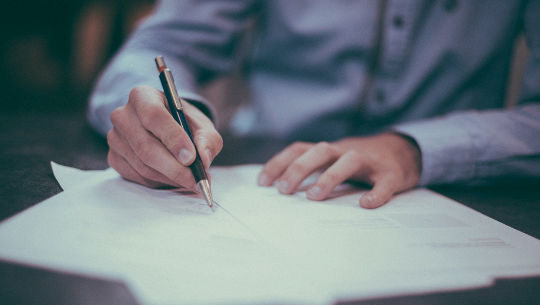 man sitting down writing