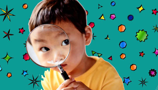 child looking through a magnifying glass