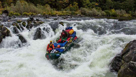 group of people riding the rapids in a raft