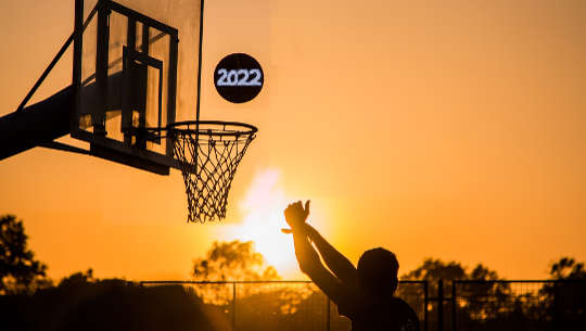 basketball playing shooting a 2022 ball into the hoop