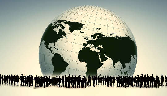 many people surrounding a black and white globe of planet earth