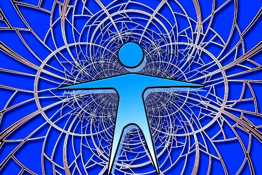 a human figure standing with arms spread out in front of a network of interwoven circles