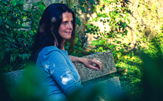 woman sitting peacefully on a bench out in nature 