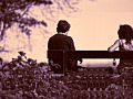 two people sitting far apart on a bench