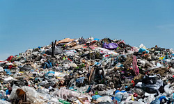 Suggested Alt Image Text:  A degraded landfill leaking into nearby soil and water, illustrating the ongoing threat of PCB pollution to the environment.