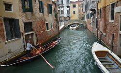 a gondola and other boats on a canal in Venice, Italy