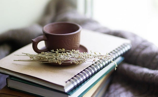 a cup with herbs next to it