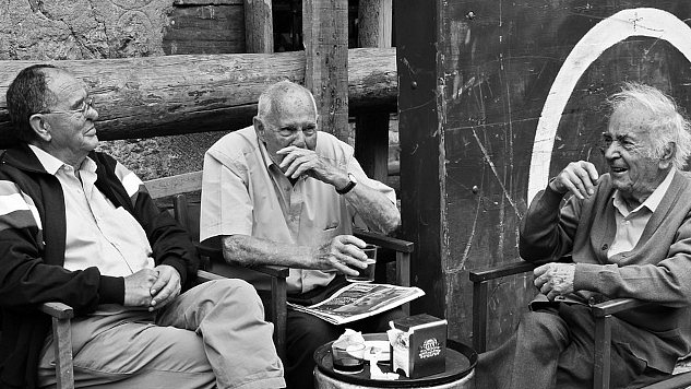 three older men sitting around talking