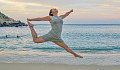 woman jumping and dancing on the beach