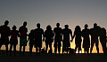 a group of people in line at the horizon, holding hands