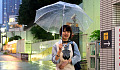 Smiling young girl walking with open umbrella