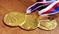 three gold medals on ribbons