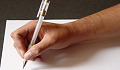 a picture of someone's hand holding a pen over a blank piece of paper