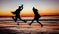 two people jumping with joy at the beach