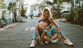 mother and child sitting on the ground in the middle of a cobblestone street