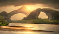 two natural archways on the other side of an expanse of water