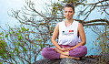 young woman sitting outside in a meditation position