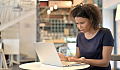 upset woman sitting in front of her open laptop computer