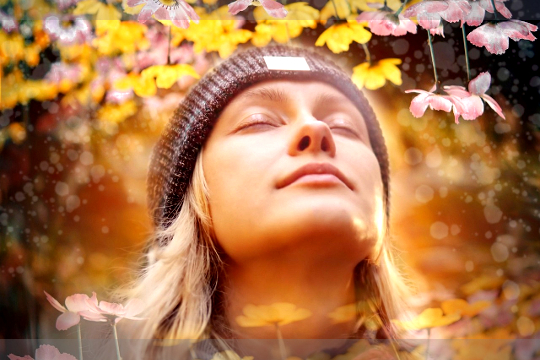 a woman, at peace with eyes closed, out in nature