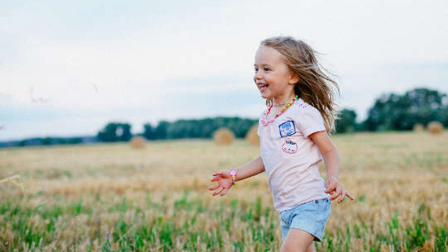 a joyful young child running through a field