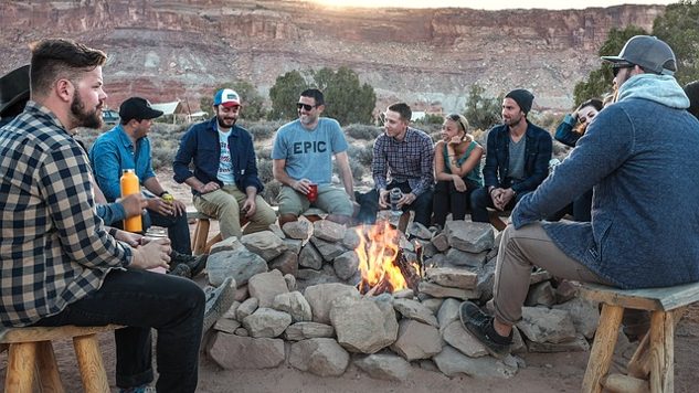 people sitting around a campfire