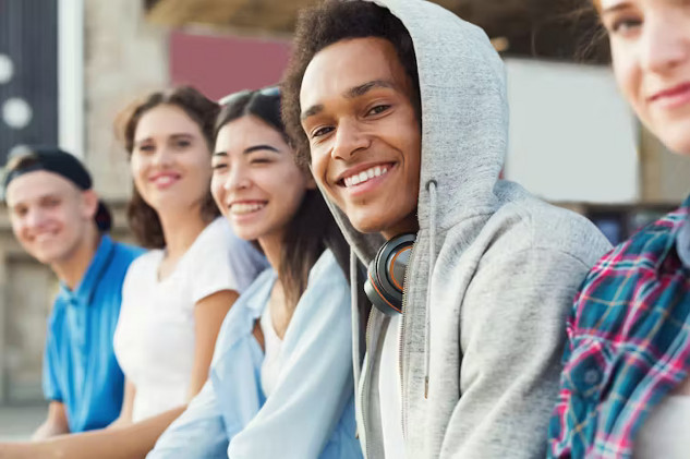 Teenager smiling while eating a healthy meal, illustrating the benefits of lifestyle changes on mental health.