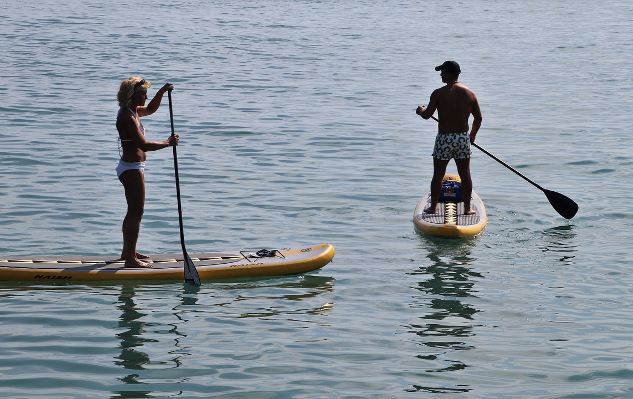 two people, a man and a woman, on paddle boards