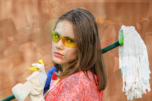 a woman wearing rubber gloves and holding a mop over her shoulder