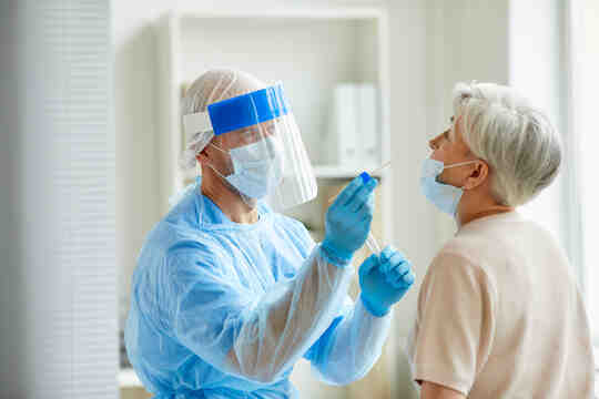 A health-care worker performs a COVID swab test on a patient.