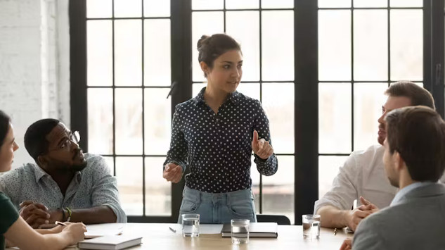 A young leader sitting at a desk, confidently reviewing documents and charts, symbolizing the process of making thoughtful, strategic decisions in a high-pressure work environment.