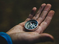 a man in a suit holding a compass in his open hand