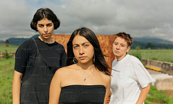 Couple facing each other with an onlooker showing interest in one partner, highlighting the impact of unwanted attention on relationships