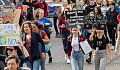 crowd of people marching with climate change signs and more