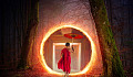 young Buddhist monk, carrying an umbrella, and entering a portal into a tree trunk