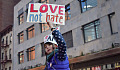 a young woman holding up a sign that reads: Love not Hate