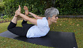 an older woman doing yoga outside