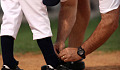 coach tying the shoe of a baseball player