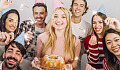 a group of friends smiling, one of them holding a birthday cake